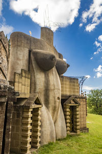 Low angle view of sculpture on building against sky