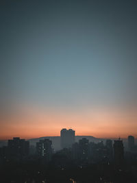 Silhouette buildings against sky during sunset