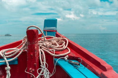 Close-up of rope tied on bollard against sky