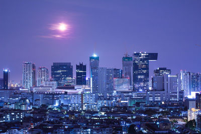 Illuminated cityscape against sky at night