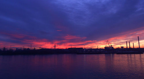 Scenic view of sea against dramatic sky during sunset