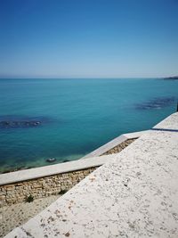 Scenic view of sea against clear blue sky. stairs connected from road to sea. 