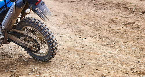 Close-up of motorcycle on dirt road