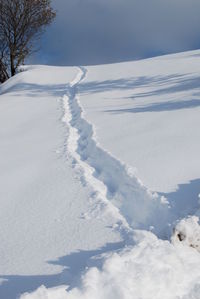 Snow covered landscape against sky