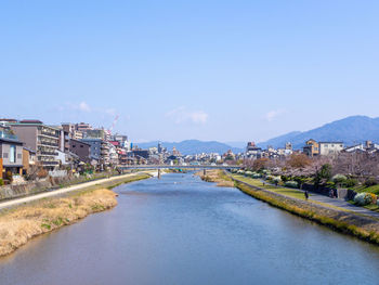 River amidst buildings in city against sky