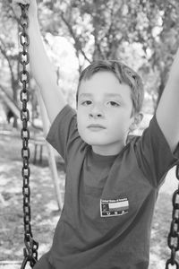 Close-up of boy on swing at playground