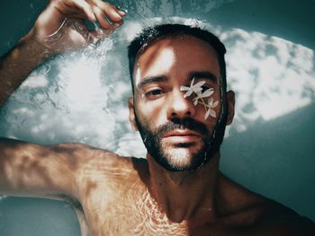 Portrait of shirtless young man in swimming pool