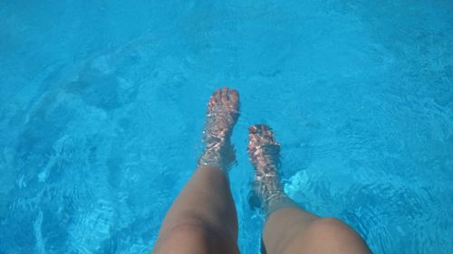 Low section of woman standing in swimming pool