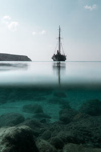 Tall ship sailing on sea against sky