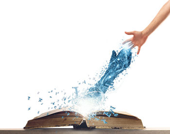 Close-up of hand splashing water against white background
