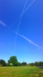 Scenic view of vapor trails against clear blue sky