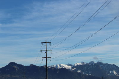 Low angle view of overhead cable car against sky