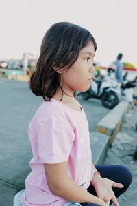 Cute girl looking away while standing outdoors