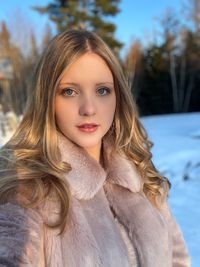 Portrait of young woman wearing warm clothing while standing outdoors