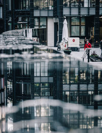 Reflection of people on bicycle in city