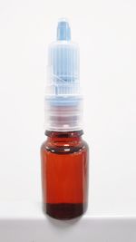 Close-up of red bottle against white background