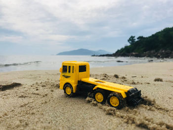 Yellow toy car on beach