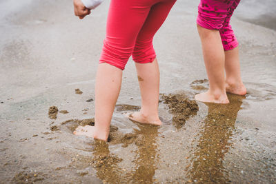 Low section of siblings standing in sea