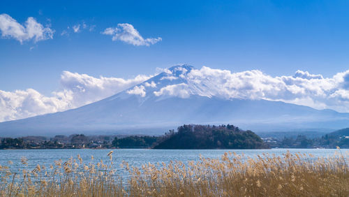 Scenic view of lake and mountains against blue sky