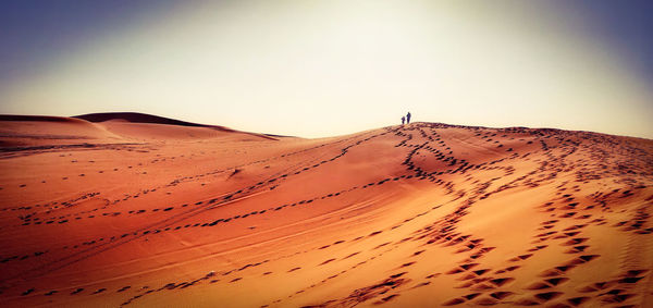 Sand dunes in desert against clear sky