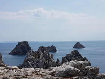 Scenic view of rocks in sea against sky