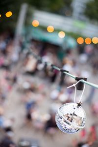 Disco ball hanging on string with people in background