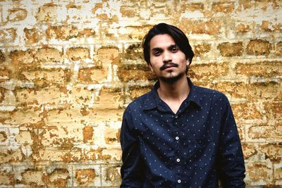 Portrait of young man against wall