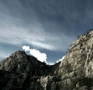 Low angle view of mountain against cloudy sky