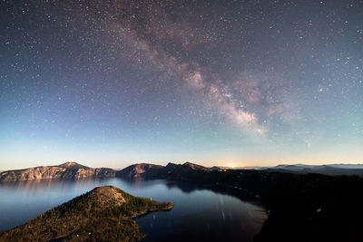 Scenic view of lake against sky at night