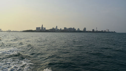 Scenic view of sea and buildings against clear sky