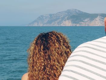 Rear view of woman standing against sea