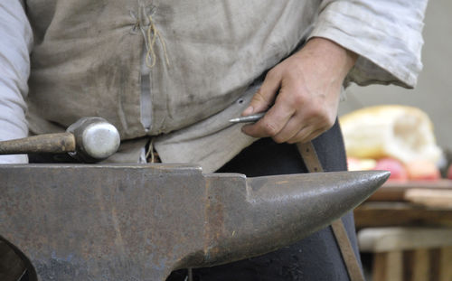 Close-up of man working on barbecue grill