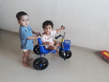 Portrait of cute boy riding toy