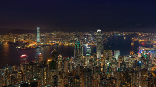 Illuminated cityscape against clear sky at night