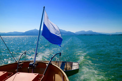 Sailboat on sea against clear blue sky