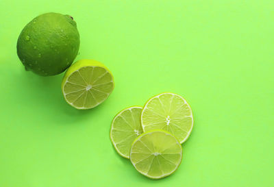 High angle view of lemon slice over green background