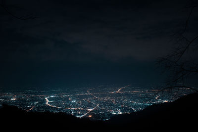 Illuminated cityscape against sky at night
