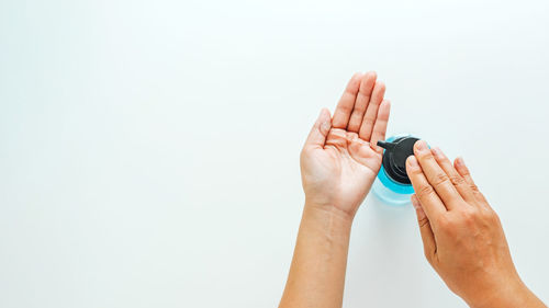 Close-up of hand holding hands over white background