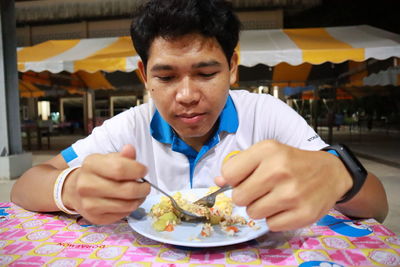 Portrait of man eating food in restaurant