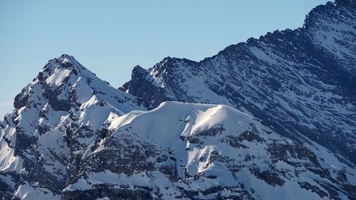 Scenic view of snowcapped mountains against clear blue sky