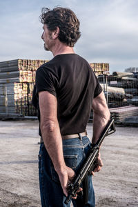 Rear view of man standing against sky in city