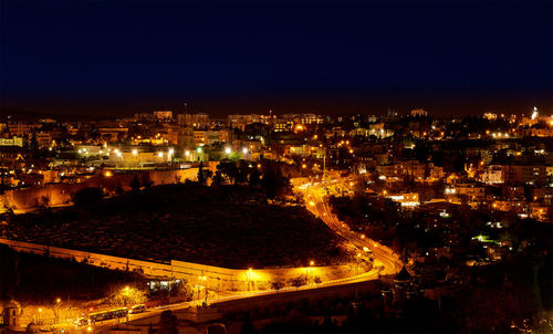 Illuminated cityscape against clear sky at night