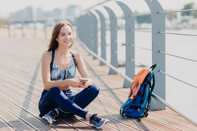 Portrait of smiling young woman sitting on floor