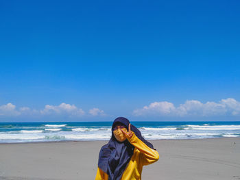 Rear view of woman standing at beach against clear blue sky. sea peace 