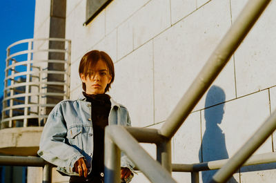 Portrait of boy standing against built structure