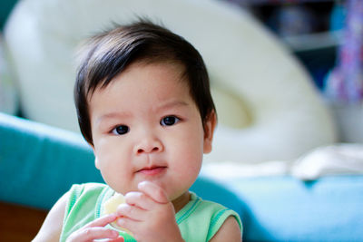 The cute asian boy toddler wearing the green vest. portrait cute asian baby with blurred background. 