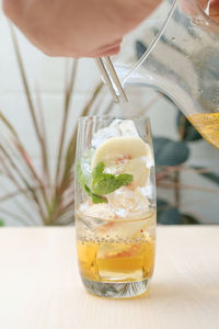 Close-up of hand holding drink on table