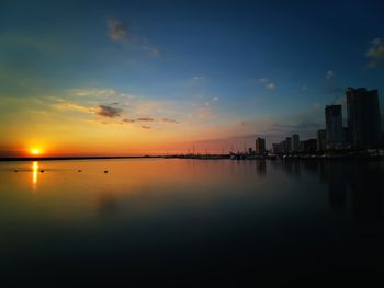 Scenic view of silhouette buildings against sky during sunset