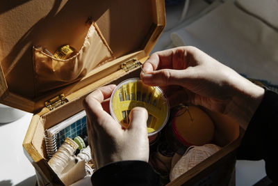 Anonymous tailor female keeps her sewing utensils in a sewing box