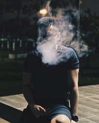 Man smoking cigarette while sitting outdoors